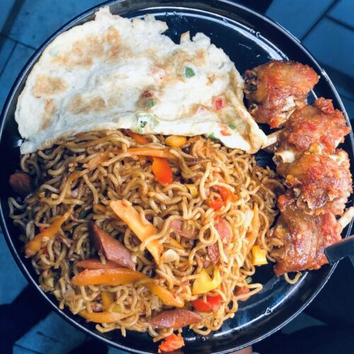 Special stir fry Nigerian noodles with chicken, sausage, assorted vegetables, and eggs