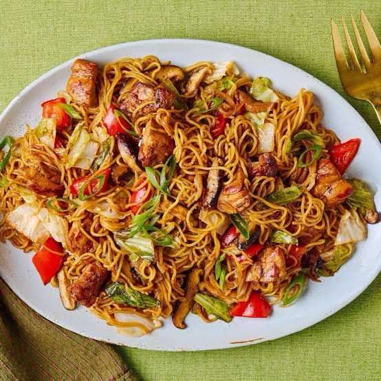 Special stir fry Nigerian noodles with chicken, sausage, assorted vegetables, and eggs